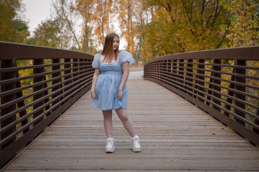 Trinity+Metcalf+is+showing+off+her+style+in+her+senior+photos+with+this+blue+puffy+dress+as+she+poses+on+a+bridge+for+her+senior+photos.+