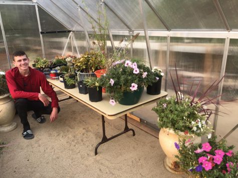 Ethan Ahlstrom posing beside one of his plant tables. 