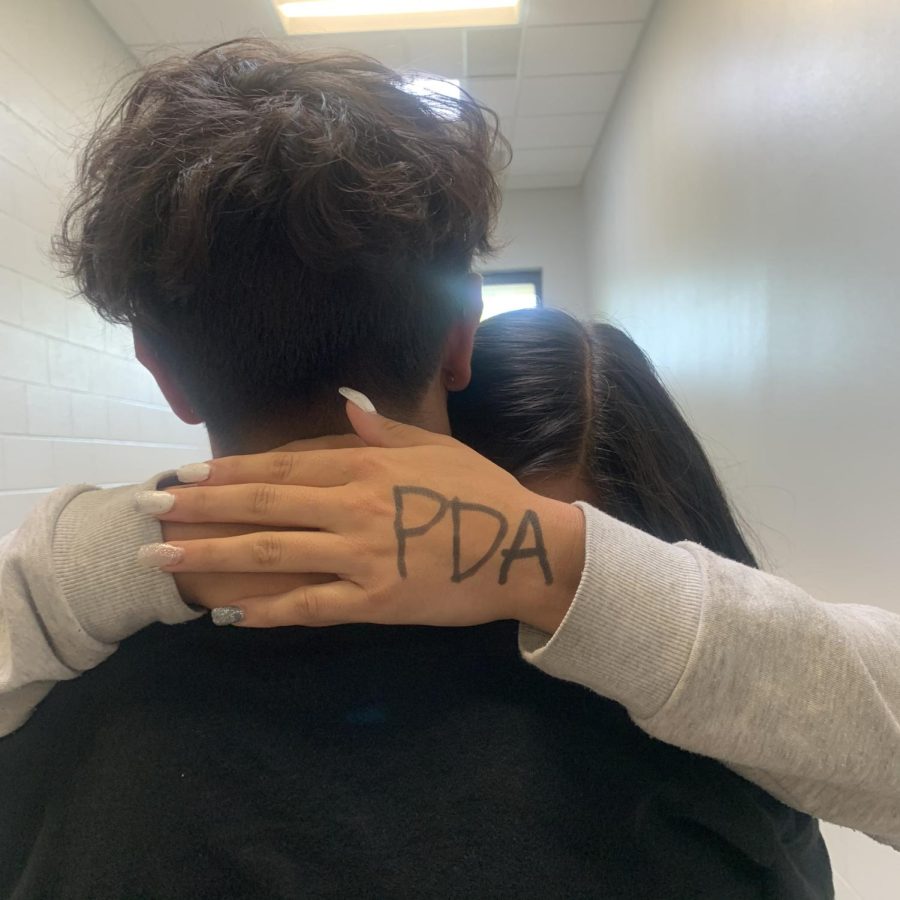 Two students are hugging in the hallway. At Frederick High School there is a growing problem of PDA.