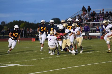 Senior Kooper Anderson tries to run past the Holy Family Tigers on a kick return. Despite putting up excellent stats and getting four touchdowns, Frederick lost its first football game of the year thanks to a last-second play by the Tigers.