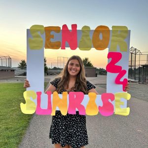Tatum smiles at the camera on her last first day of high school during the senior sunrise. Her bright smile welcomes all as she reveals joy, warmth, and happiness. Tatum has many goals to accomplish and she is already paving her path towards success one step at a time.