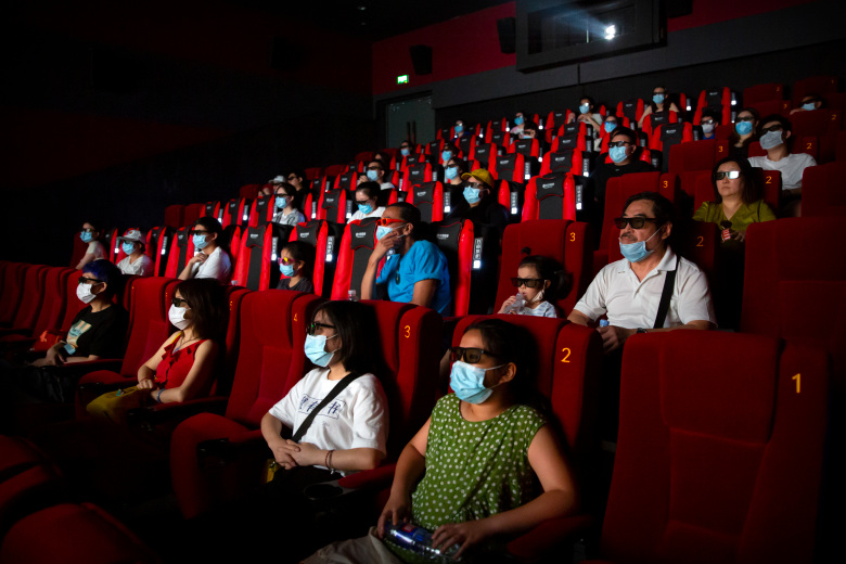 People wearing face masks to protect against the coronavirus watch the film Dolittle at a movie theater in Beijing, Friday, July 24, 2020. Beijing partially reopened movie theaters Friday as the threat from the coronavirus continues to recede in China’s capital. (AP Photo/Mark Schiefelbein)