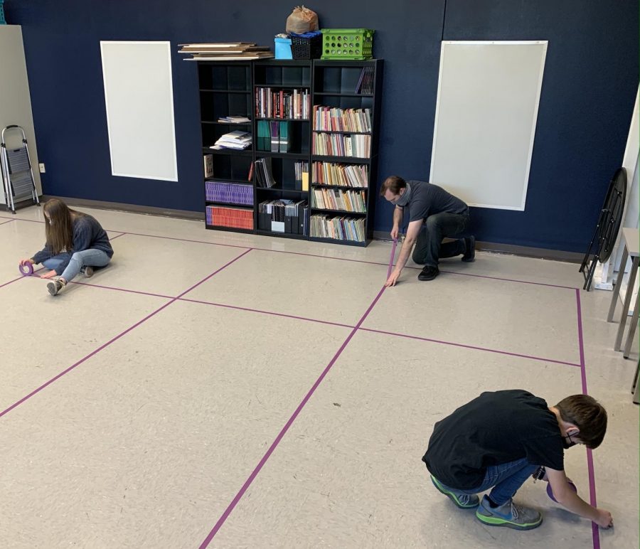 Mr. Coon with students Kayla and Rylee Lorimer taping down six foot boundaries on the ground for Drama classes. Like many FHS teachers, Mr. Coon spent his Friday preparing his classroom for the return of students to Frederick High. 