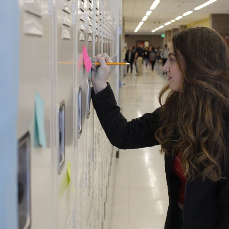Junior Ella Berrend writes a kind note on a locker as part of NHSs push to make finals a little less stressful.