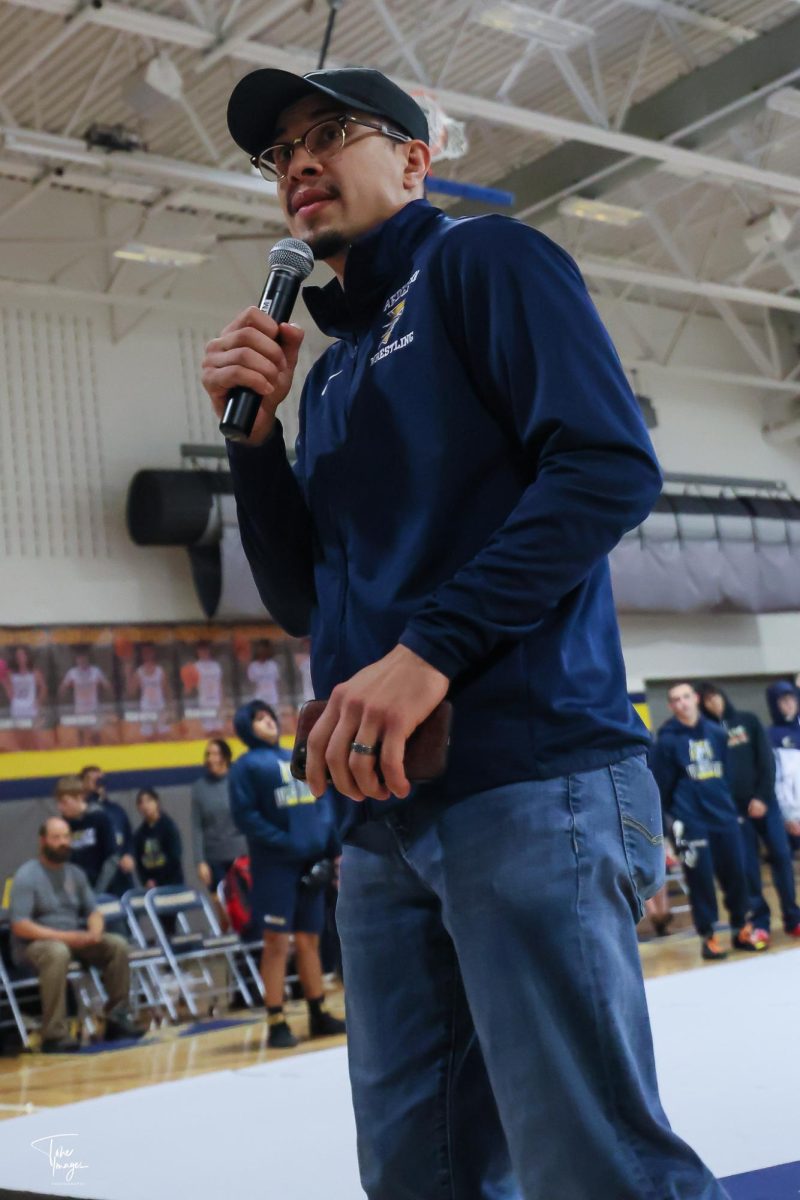 Coach Anthony Medina announcing before a home duel. Junior Niko Carrillo states, “Anthony is a great wrestler with tons of experience and knows what to do in every wrestling match, I enjoy him as a person. He shows me insight into what my wrestling style should be.”