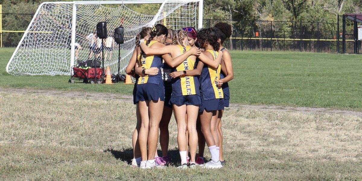 The Frederick girls varsity team huddles as they prepare for their race. This is a tradition they have at the beginning of every meet that brings the energy to every race. 