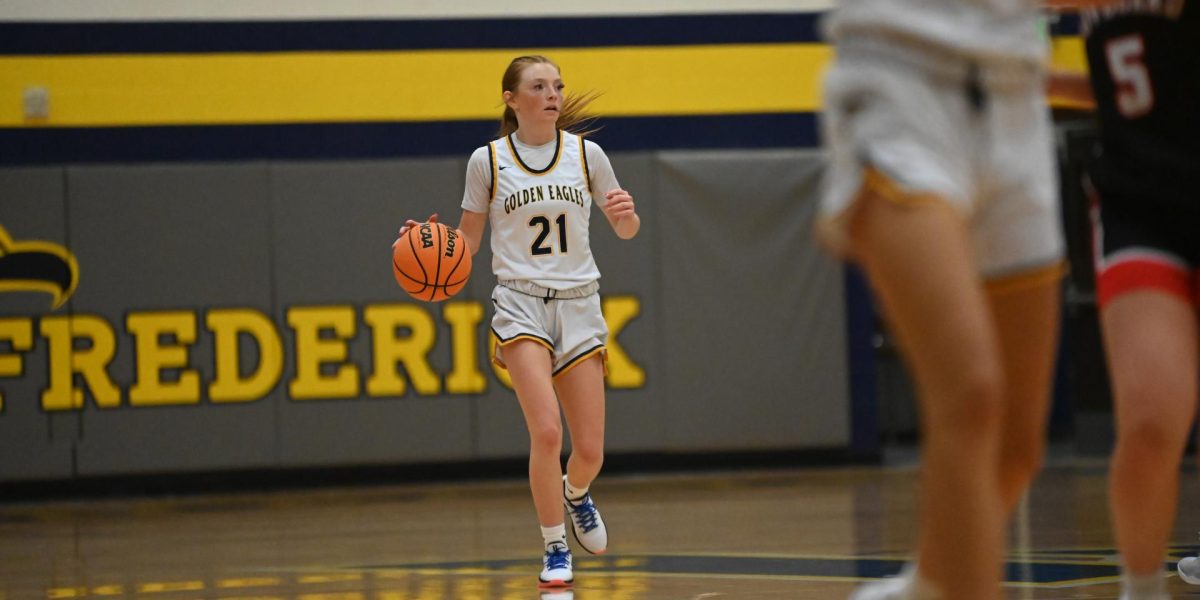 Ball in hand, Avery Salisbury looks across the court as she plans for the next play. Throughout the game, Avery was a prominent playmaker, helping the team continuously put points on the board.