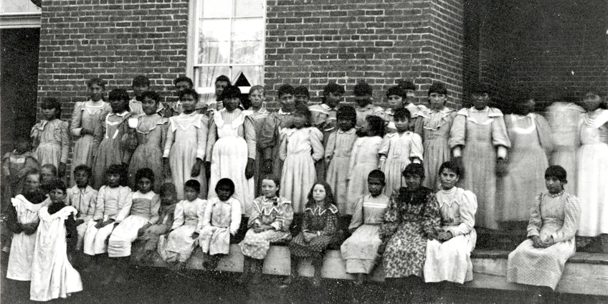 An entire class of indiginous girls pose outside Fort Lewis Indian Boarding School. Federal Indian Boarding Schools (FIBS) were in operation around the US between 1879 and 1934 and were the sites of some of the most despicable cruelty in US history. The federal government operated seven of these schools in Colorado, and a new state commission has formed to look into the abuses that occurred at these schools.  (Courtesy of Center of Southwest Studies, Fort Lewis College)