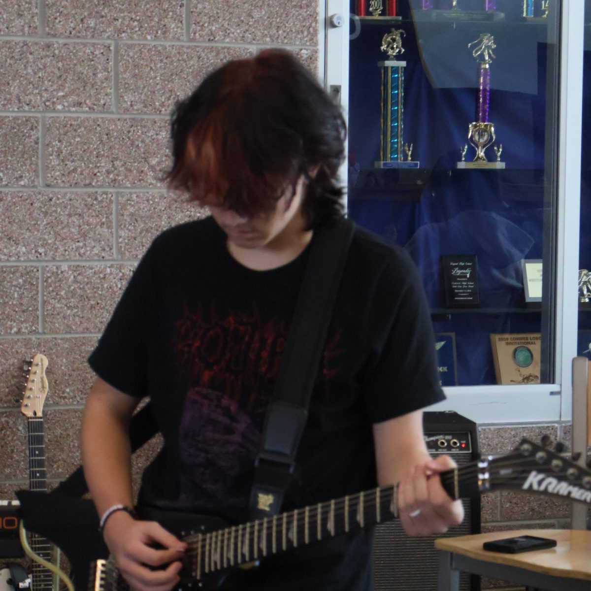 Junior Luke Mikesell plays guitar as part of the School of Rock lunchtime performance. Each set was applauded and well received by the captive audience in the commons. "I was really happy with the student body engagement, especially during first lunch," Mr. Liss said. "People got into the show, and that was really exciting to see!"