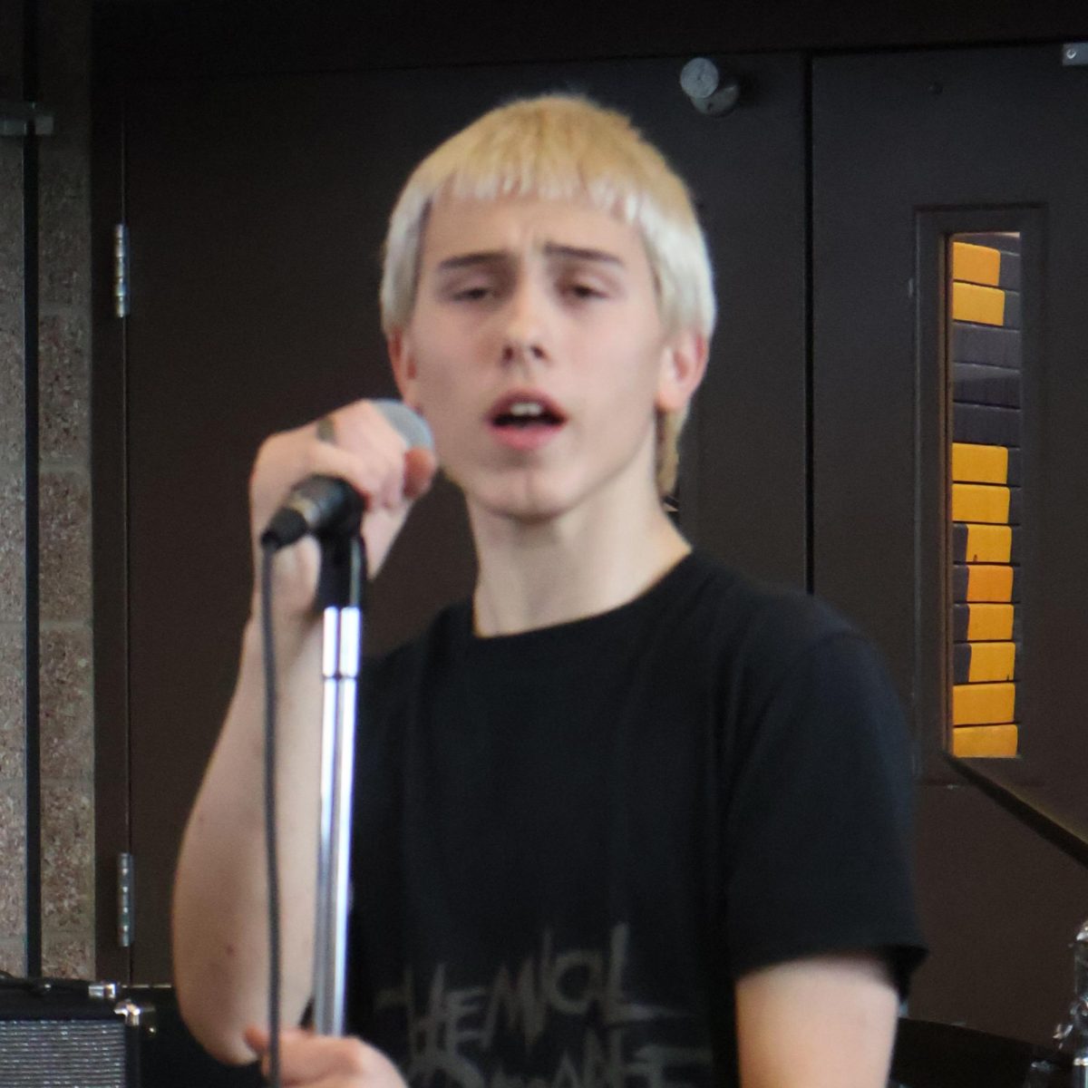 Sophomore Atticus O’Connell sings during School of Rock's cafeteria performance. “I don’t think I would change anything from the performance," Atticus said. "I think it was great to show our talent as a group. All of the songs went really well for us.”