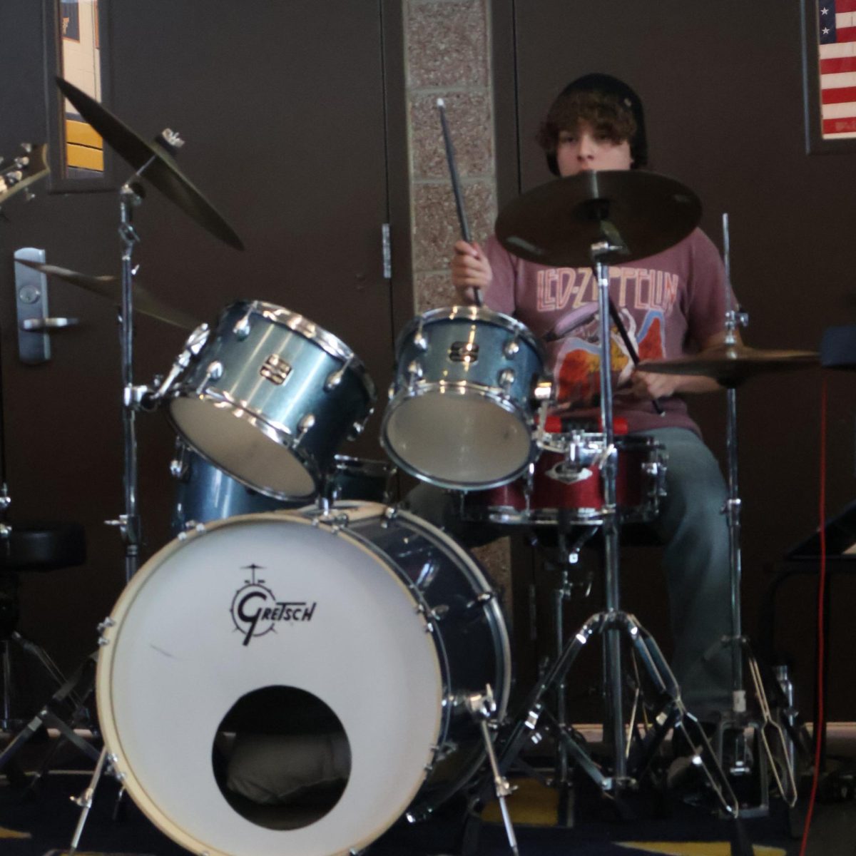 Junior Erik Esqueda-LeRoi peeks out from behind his drumset during School of Rock's lunchtime set. "Being a drummer, my mind is constantly working through the whole song, thinking about the rhythm and consistency as well as what my next move is," Erik said. "I'm looking out for changes in the song and also making sure we are all together as a group."