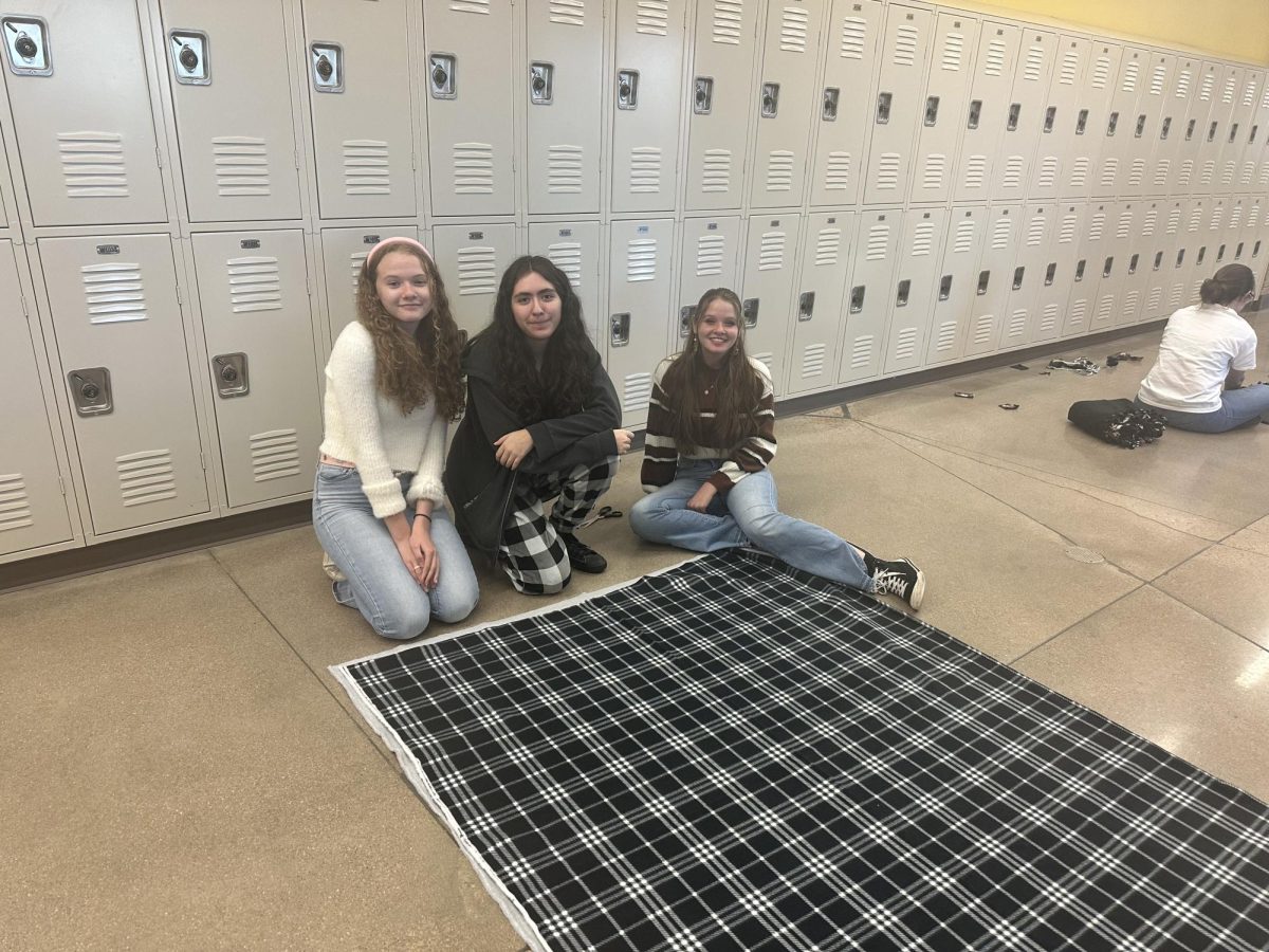 FHS students Maddix Frame, Valerie Madrid, and Peyton Frame sit next to their pieces of fleece before crafting it into a blanket. With three people, a single blanket can take as little as 15 minutes.