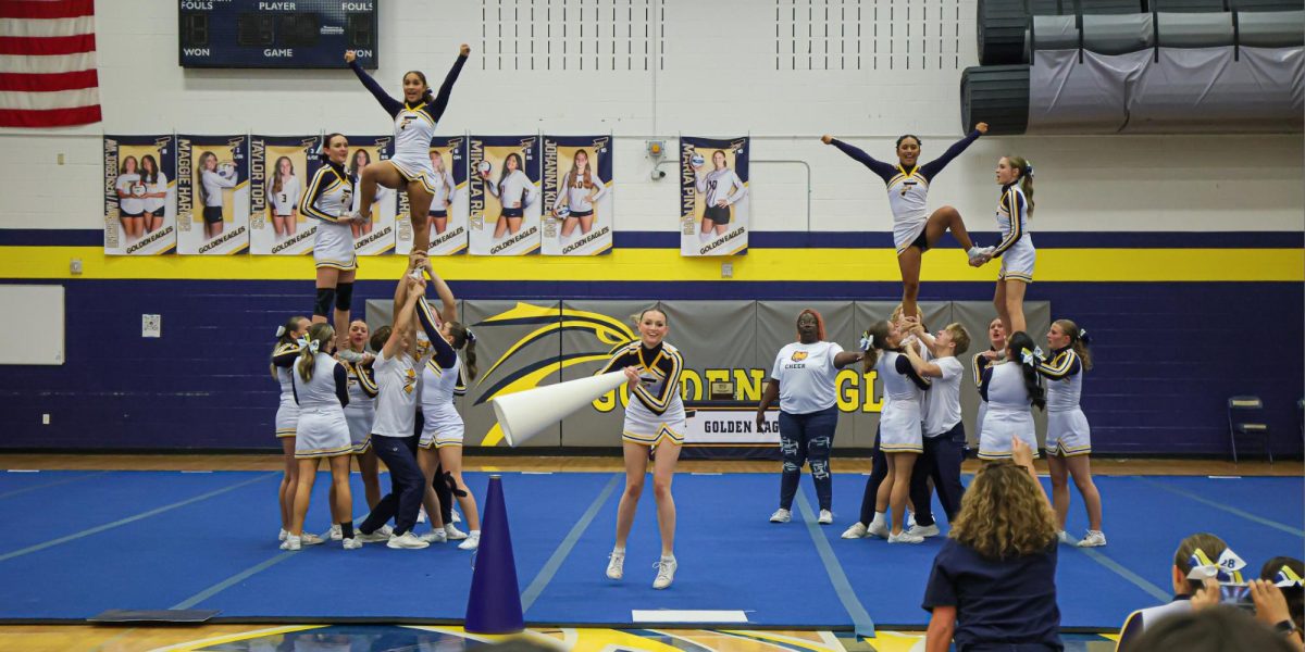 The Frederick Cheer Team stunts at a cheer competition hosted by Frederick High School. The cheer team, which recently went co-ed, is one of the most expensive sports programs at Frederick with all of its additional fees and costs. 