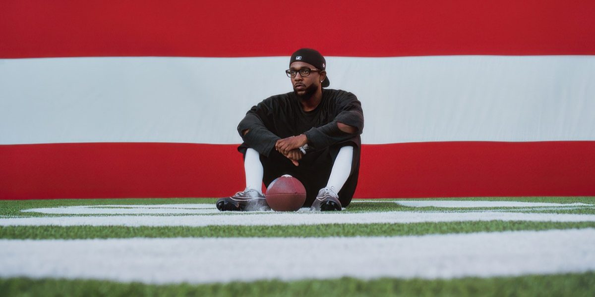 In this promotional image by Apple Music to promote this year's Super Bowl Halftime Show, Kendrick Lamar sits on the 50-yard line in front of a giant American flag. Kendrick pulled off, if not the best, then the most meaningful halftime performance of the past decade. His performance was more than just performing his hits—he used the nationally-watched event as a platform for his politics.