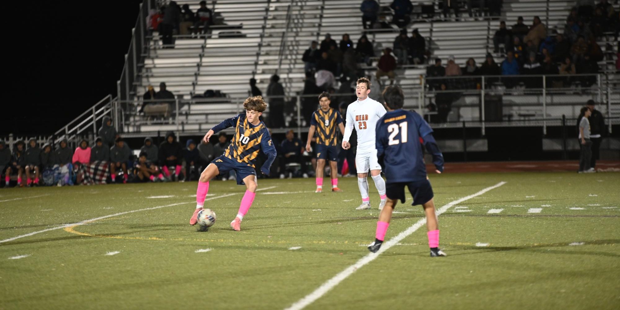 Junior Gavin Coburn dribbles around an opponent during one of the team's games on their home field. The main field at Frederick, used for football, boys and girls soccer, and track is made of turf. Turf is an artificial grass composed of "soft plastic blades of “grass” that come in large sections with a plastic backing made for drainage and the infill, a mixture of rubber pellets and sand that can be made from cork, coconut or plastic” according to AP News.