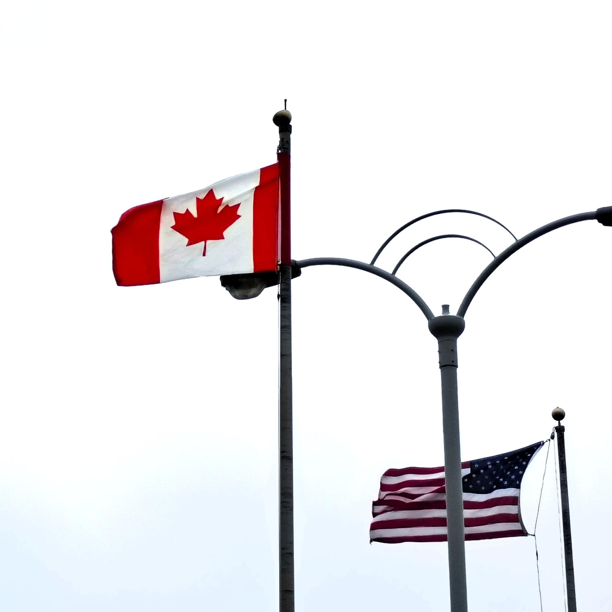 The Canadian and American flags fly over the US-Canadian border at Niagara Falls, NY.