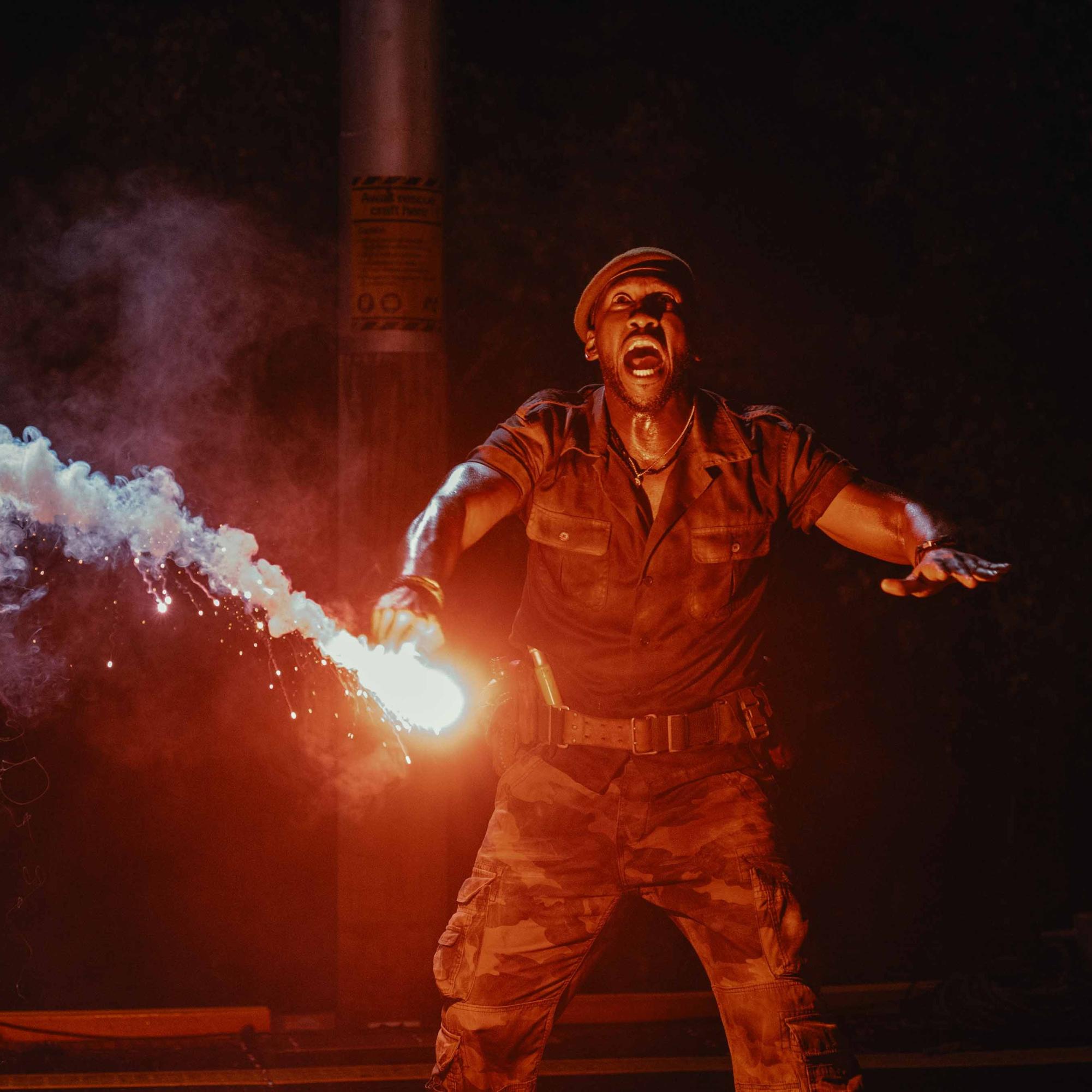 Mercenary captain Duncan Kincaid (Mahershala Ali) uses a flare to get the attention of a D-Rex. (Universal)