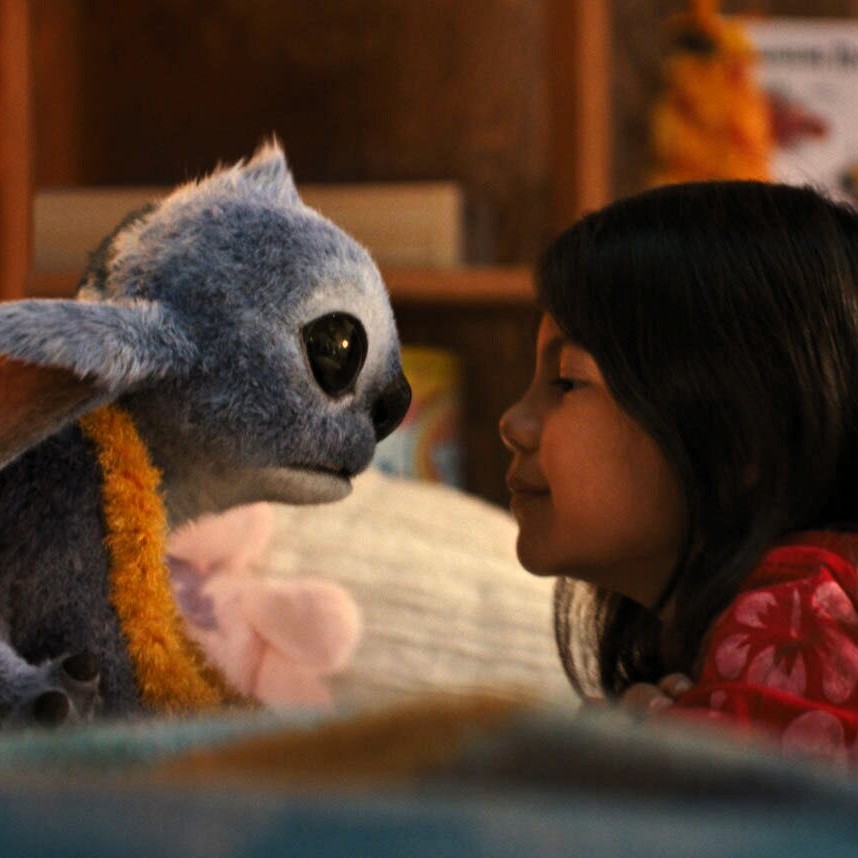 Stitch bonds with his new "owner" Lilo (Maia Kealoha) in Lilo's bedroom. (Disney)
