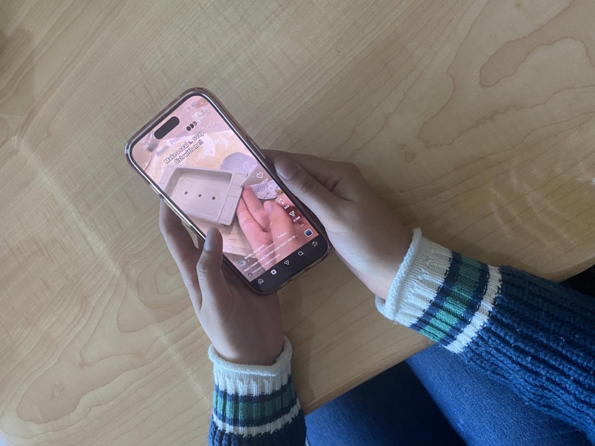 A student doomscrolling Instagram reels on their phone. 
